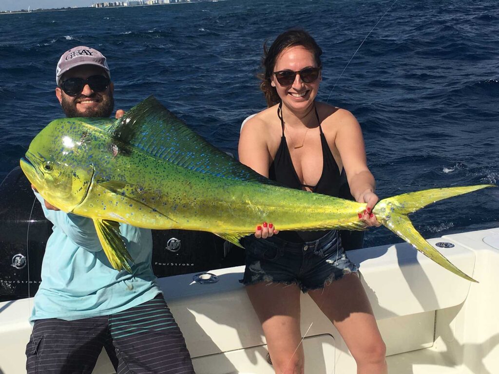 Female angler and companion holding a beautiful dolphin fish.