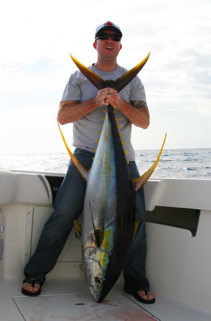 Angler holding a colorful yellowfin tuna.