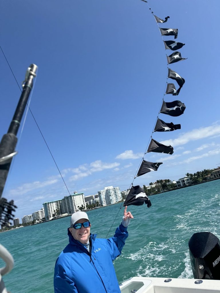 Angler pointing to the eleven sailfish release flags