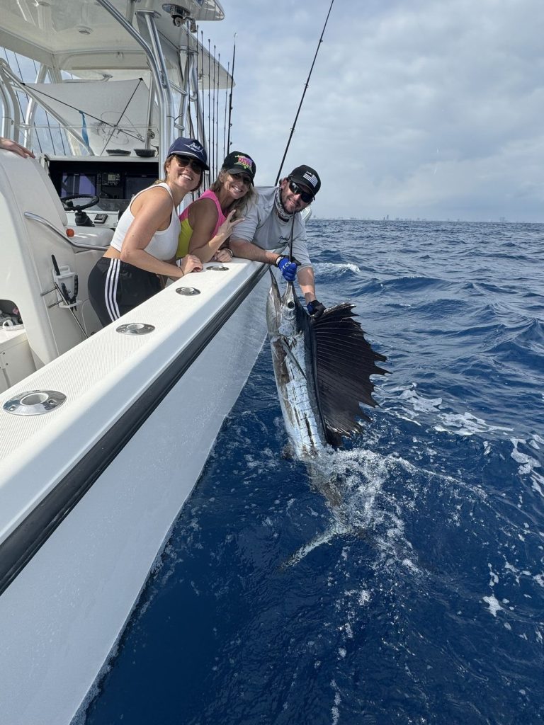 Two female anglers about to release a sailfish with the Miami skyline in the background