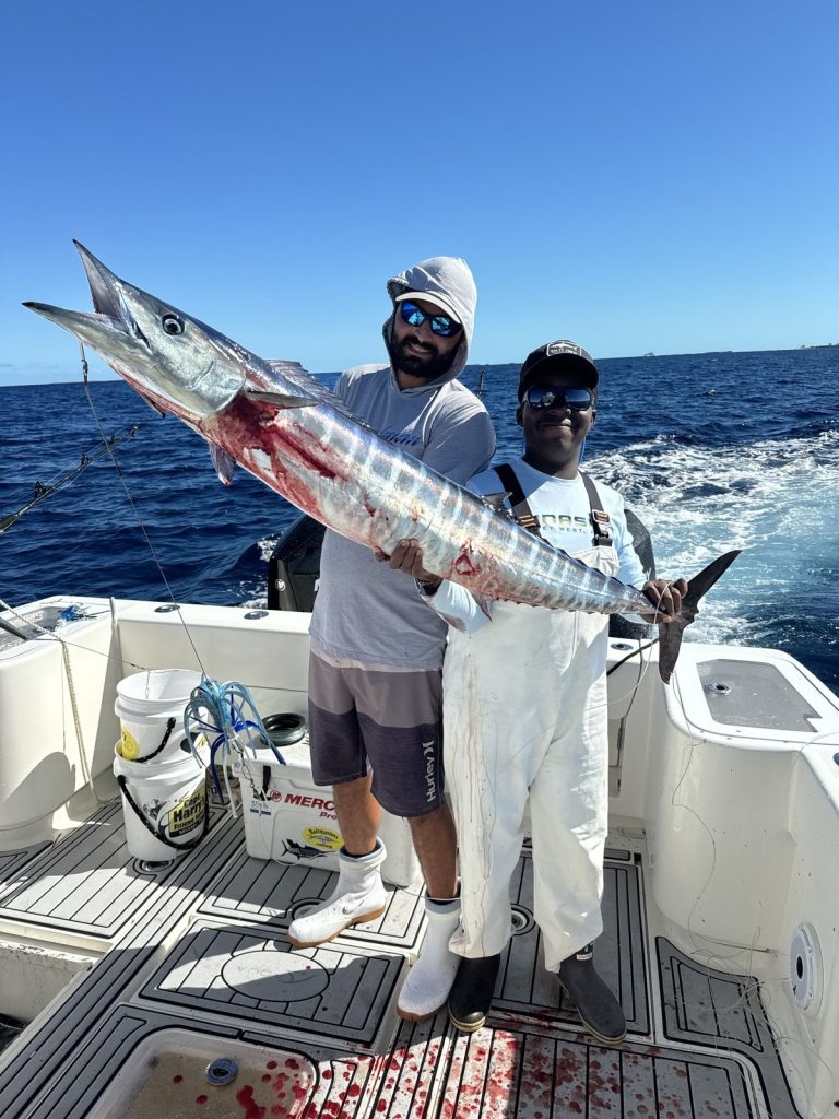 Anglers with a nice wahoo caught while high speed trolling